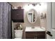 Small bathroom featuring an oval mirror, dark cabinet, patterned shower curtain, and tiled accents at 6611 Valley Mills Ave, Indianapolis, IN 46241