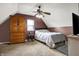 Slanted-ceiling bedroom with a ceiling fan, armoire, plush carpet, and natural light from a window at 6611 Valley Mills Ave, Indianapolis, IN 46241