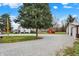 Exterior view with a large yard, gravel driveway, and a storage shed at 6611 Valley Mills Ave, Indianapolis, IN 46241