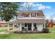 Charming two-story home with a welcoming porch and red shutters, complemented by a well-maintained lawn and mature trees at 6611 Valley Mills Ave, Indianapolis, IN 46241