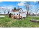 Exterior view of white home with mature landscaping, large yard, and red door at 6611 Valley Mills Ave, Indianapolis, IN 46241