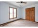 Simple bedroom with neutral carpet, a ceiling fan, natural light from the window, and a closet at 6628 Moss Cir, Indianapolis, IN 46237