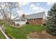 Back exterior view of the home featuring the sunroom addition and manicured lawn at 6628 Moss Cir, Indianapolis, IN 46237