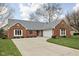 Charming brick home featuring an attached two car garage and well maintained lawn and driveway at 6628 Moss Cir, Indianapolis, IN 46237