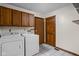 Functional laundry room featuring a washer, dryer, and wooden cabinets for storage at 6628 Moss Cir, Indianapolis, IN 46237