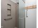 Accessible shower featuring grab bars, a built-in shelf, and a frosted glass door at 6628 Moss Cir, Indianapolis, IN 46237
