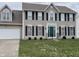 Charming two-story home featuring a green front door, black shutters, and well-manicured lawn at 6816 Russett Dr, Plainfield, IN 46168