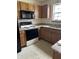 Functional kitchen with oak cabinets, granite countertops, and modern black appliances at 6816 Russett Dr, Plainfield, IN 46168