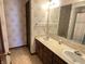 Bathroom featuring double vanity, mirror, and wallpapered walls at 7164 Sandalwood Dr, Avon, IN 46123