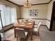 Staged dining room featuring a chandelier, large window and a wooden dining table with six chairs at 7164 Sandalwood Dr, Avon, IN 46123