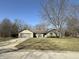 Charming single-story home featuring a stone facade and attached garage, set on a spacious lot with mature trees at 7164 Sandalwood Dr, Avon, IN 46123