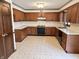 Bright kitchen featuring wood cabinets, neutral countertops and black appliances at 7164 Sandalwood Dr, Avon, IN 46123