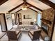 Staged living room featuring a stone fireplace, vaulted ceilings with exposed beams, and lots of natural light at 7164 Sandalwood Dr, Avon, IN 46123