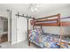 Inviting bedroom with bunk bed, closet with barn door, and ceiling fan, creating a cozy and functional space at 7254 Cambridge Pl, Avon, IN 46123
