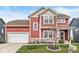 Charming two-story home with a red exterior, stone accents, and a well-maintained lawn at 7254 Cambridge Pl, Avon, IN 46123