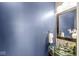 Stylish powder room with modern glass sink, decorative mirror, and blue accent wall at 7254 Cambridge Pl, Avon, IN 46123