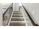 Carpeted staircase with dark wood railing leads to the upper level of the home at 7254 Cambridge Pl, Avon, IN 46123