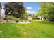 Expansive backyard featuring a fire pit, shed, and lush green lawn, perfect for outdoor entertaining at 7383 Poppyseed Dr, Indianapolis, IN 46237