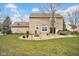 Backyard with an in-ground fire pit, stone pavers, well-manicured lawn, and access to the home's back door at 7383 Poppyseed Dr, Indianapolis, IN 46237