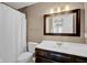 Traditional bathroom with dark vanity, white sink and toilet, and a shower with a curtain at 7383 Poppyseed Dr, Indianapolis, IN 46237