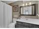 Charming bathroom with a vanity, decorative mirror, and shower with a white curtain at 7383 Poppyseed Dr, Indianapolis, IN 46237