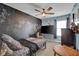 Bright bedroom with a chalkboard accent wall, complemented by carpeted floors, a window, and ceiling fan at 7383 Poppyseed Dr, Indianapolis, IN 46237