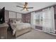 Cozy bedroom features a ceiling fan, patterned walls and decor, with ample natural light through the large window at 7383 Poppyseed Dr, Indianapolis, IN 46237
