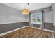 Inviting dining room featuring chair rail, modern lighting fixture, and hardwood floors at 7383 Poppyseed Dr, Indianapolis, IN 46237