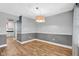 Inviting dining room featuring chair rail, modern lighting fixture, and hardwood floors at 7383 Poppyseed Dr, Indianapolis, IN 46237