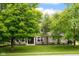 Charming two-story home with a well-manicured lawn and beautiful, mature trees at 7383 Poppyseed Dr, Indianapolis, IN 46237