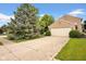 A long driveway leads to an attached two-car garage, surrounded by a green lawn and mature trees at 7383 Poppyseed Dr, Indianapolis, IN 46237