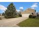 Attached two-car garage with wide driveway, mature landscaping, and lawn at 7383 Poppyseed Dr, Indianapolis, IN 46237