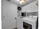 Bright laundry room with white cabinets, white appliances, and decorative touches at 7383 Poppyseed Dr, Indianapolis, IN 46237