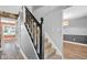 Elegant staircase with dark wood railing and carpeted steps leading to an open living space at 7383 Poppyseed Dr, Indianapolis, IN 46237