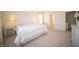 Bright bedroom with a white quilt bed, side tables with lamps, and a view of the bathroom at 7713 Imperial Eagle Dr, Zionsville, IN 46077