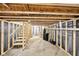 Spacious unfinished basement with exposed wood framing, concrete flooring, and utility connections at 7845 Bluff Rd, Indianapolis, IN 46217