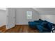 Cozy bedroom space with vaulted ceilings, wood flooring, and a comfy blue couch at 7845 Bluff Rd, Indianapolis, IN 46217