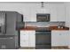Well-lit kitchen with new appliances, butcher block countertops and subway tile backsplash at 7845 Bluff Rd, Indianapolis, IN 46217