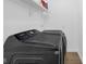 Efficient laundry room features modern black Samsung washer and dryer set, with a storage shelf at 7845 Bluff Rd, Indianapolis, IN 46217