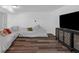 Bright living room with sectional couch, television, and light colored wood floors at 7845 Bluff Rd, Indianapolis, IN 46217