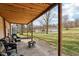 Covered outdoor patio with seating area overlooking a spacious backyard and detached garage at 7845 Bluff Rd, Indianapolis, IN 46217