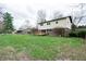 Expansive backyard with lush lawn, wooden deck, and the home's back exterior featuring large windows at 8151 Taunton Rd, Indianapolis, IN 46260