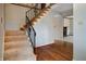 Inviting foyer featuring a staircase with decorative wrought iron railing and hardwood floors at 8151 Taunton Rd, Indianapolis, IN 46260