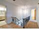 Carpeted hallway with metal railing leading to a bathroom and rooms at 8151 Taunton Rd, Indianapolis, IN 46260