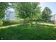 Large, grassy backyard featuring mature trees and thoughtful landscaping at 10309 Buckshire Ln, Indianapolis, IN 46234