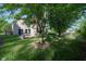 Lush backyard featuring mature trees, lawn, birdhouses and back of home at 10309 Buckshire Ln, Indianapolis, IN 46234