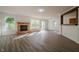 Open living room with a stone fireplace, sliding glass doors and a view into the kitchen at 10309 Buckshire Ln, Indianapolis, IN 46234