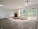 Spacious living room with stone fireplace, hardwood floors, light fixture, and sliding glass door to the backyard at 10309 Buckshire Ln, Indianapolis, IN 46234