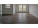 Living room with neutral walls, wood-look flooring, and natural light from two windows at 10309 Buckshire Ln, Indianapolis, IN 46234