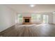 Bright and spacious living room with stone fireplace, wood-look floors, and sliding glass door at 10309 Buckshire Ln, Indianapolis, IN 46234